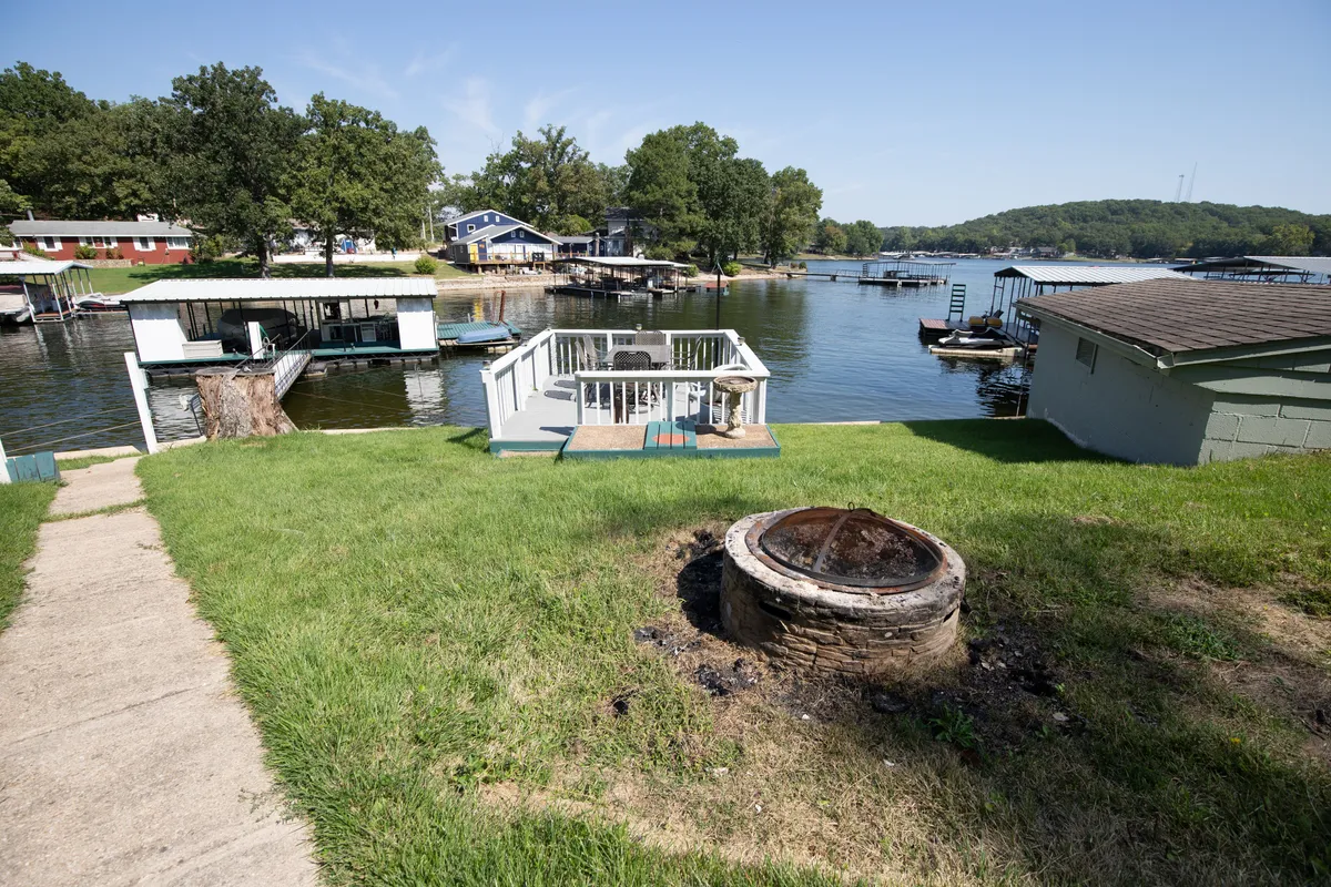 This photo highlights an inviting deck area with a fire pit overlooking the lake. The setup hints at communal gatherings, lakeside barbecues, and fireside conversations, all set against a picturesque water view. The image evokes the leisurely and social experiences that define a stay at Lake of the Ozarks.